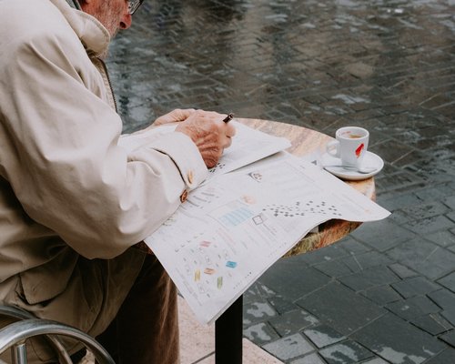 Man writing in a journal with a cup of tea